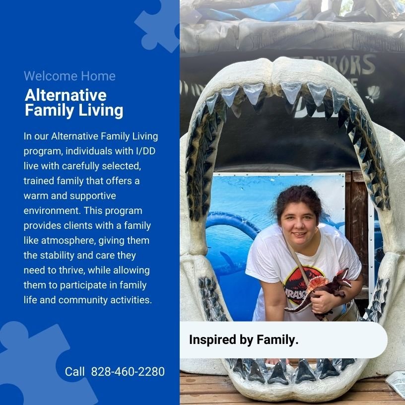 A woman smiling inside a large shark mouth prop at a family living program event. The event promotes alternative family living for individuals with I/DD.